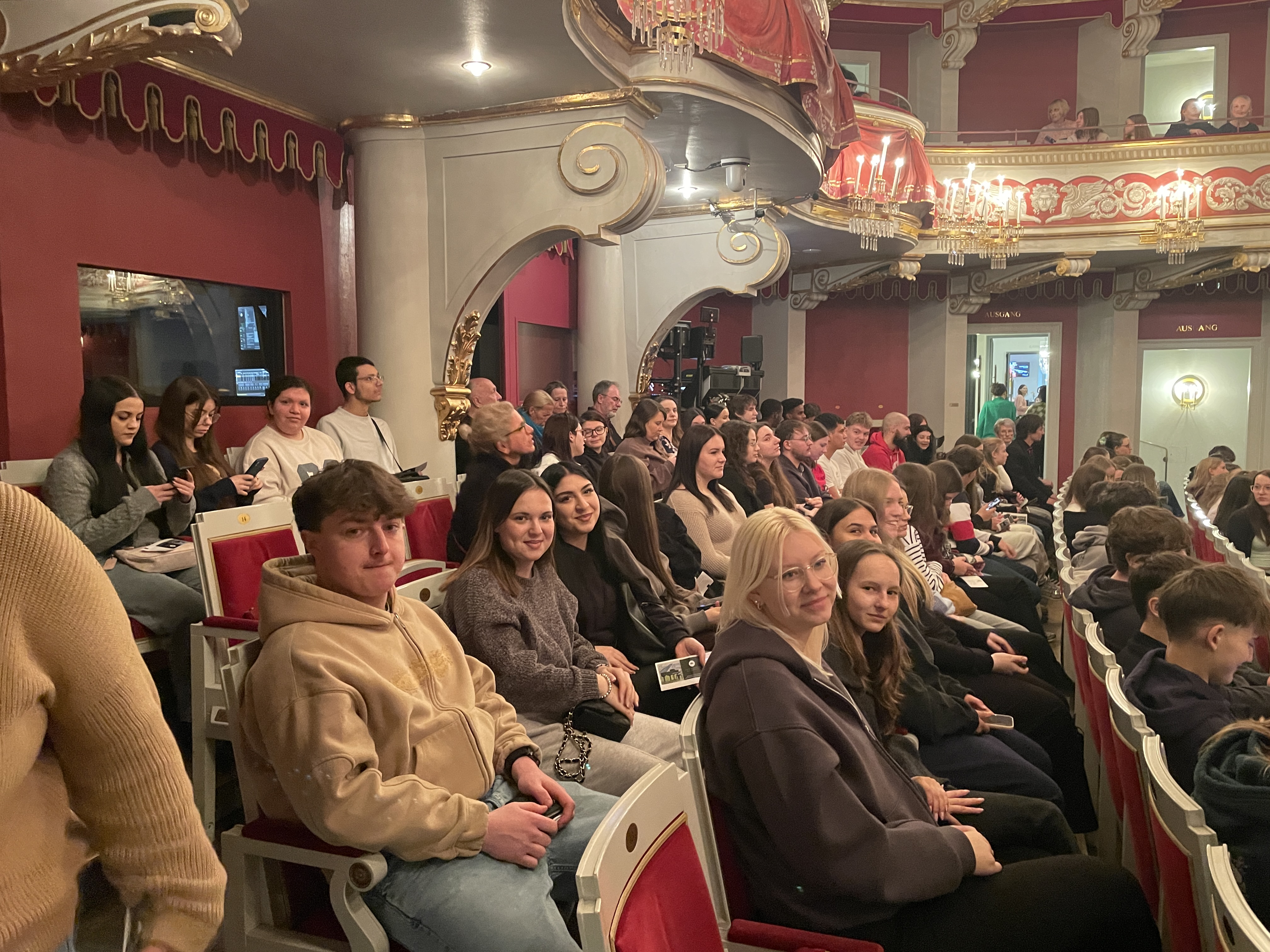 Schülerinnen und Schüler der Kaufmännischen Berufsschule im historischen Zuschauerraum des Theaters Regensburg kurz vor Beginn des Musicals „Charlie und die Schokoladenfabrik“.